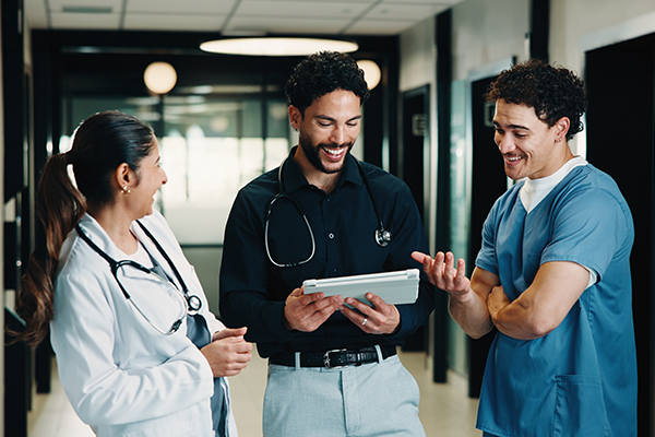 Clinicians smiling while looking at a tablet